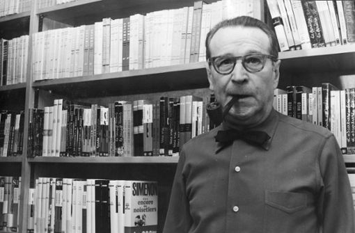 Georges Simenon (1903-1989) steht hier vor Belegexemplaren seiner Bücher – aber das Regal fasst nur einen winzigen Ausschnitt seines enormen Schaffens. Foto: Getty