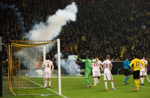 Feuerwekskörper und Rauchbomben fliegen in Dortmund aus dem Istanbuler Fanblock. Foto: dpa