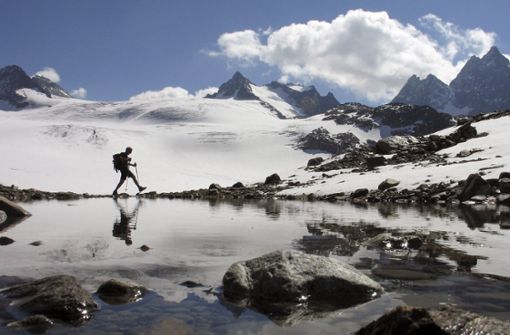 Ein Mann wandert über den Silvretta-Gletscher in der Nähe von Klosters (Archivfoto vom 16.09.2007). Schmelzende Gletscher in den Schweizer Alpen sind ein zunehmendes Problem. Foto: KEYSTONE