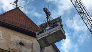 Am Donnerstagvormittag hievten die Arbeiter die neuen Ziffernblätter per Kran am Turm der Ehninger Kirche hinauf. Foto: Eibner-Pressefoto/Roger Bürke