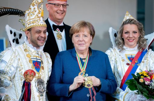 Angela Merkel steht mit Bonna Katharina III. und Prinz Richard I. vom Festausschuss Bonner Karneval e.V., Nordrhein-Westfalen sowie  Klaus-Ludwig Fess, Präsident des Bundes Deutscher Karneval, zusammen. Foto: dpa/Kay Nietfeld
