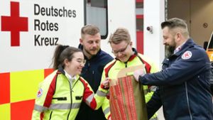 In der Leonberger Rettungswache verteilt der Rettungsdienstleiter Sven Peters (rechts) am 24. Dezember Geschenke an Mitarbeitende im Dienst. Foto: /Simon Granville