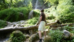 Ein Wanderer ist am Uracher Wasserfall unterwegs. Foto: dpa