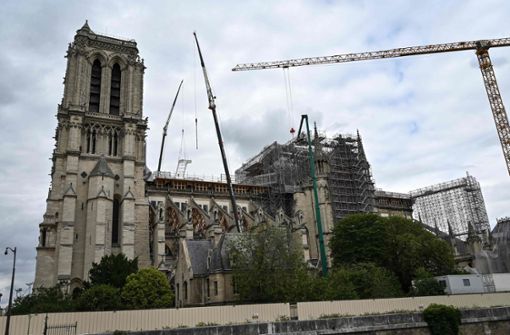Mit riesigen Kränen wird das beim Brand geschmolzene Gerüst in Einzelteilen von der Kathedrale Notre-Dame geholt. Arbeiter haben die insgesamt 40 000 Eisenstangen vorher zersägt. Foto: AFP/BERTRAND GUAY