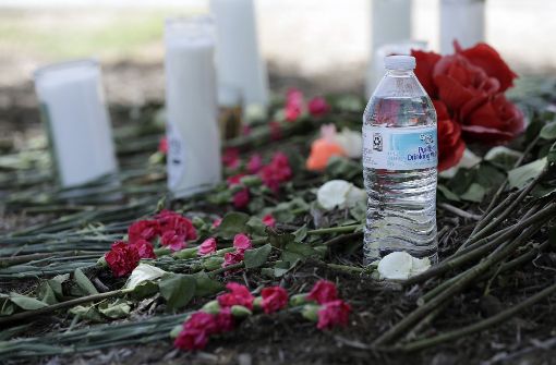 Blumen und Kerzen erinnern an die zehn gestorbenen Flüchtlinge auf dem Parkplatz eines Supermarktes in San Antonio. (Archivfoto) Foto: AP
