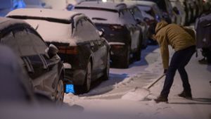 Stuttgart: Ein Mann schippt Schnee vom Bürgersteig. Foto: dpa/Sebastian Gollnow
