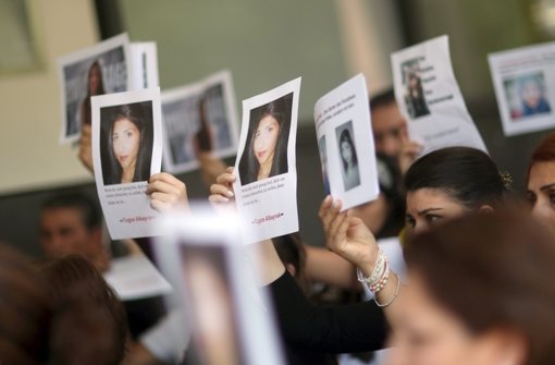 Angehörige und Freunde von Tugce halten vor der Urteilsverkündung Bilder der 22-Jährigen im Gerichtssaal hoch Foto: dpa
