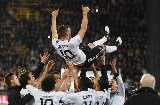 Lukas Podolski lebe hoch: Die Nationalmannschaft weiß, dass sie einen ganz Großen verliert. Foto: dpa