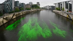 Das Wasser der Spree im Regierungsviertel  leuchtet in grüner Farbe. Foto: AFP/TOBIAS SCHWARZ