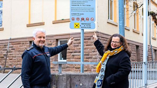 Feuerwehrkommandant Hans-Peter Peifer und die Erste Bürgermeisterin Renate Schmetz weisen auf die neuen Schilder an den Schulen  hin. Foto: Stadt Ludwigsburg/B. Stollenberg