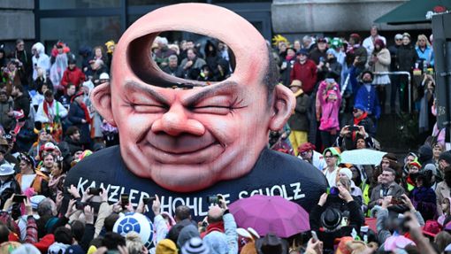 Der Mottowagen, der Kanzler Scholz als „Kanzler Hohlaf Scholz“ darstellt, fährt im Rosenmontagszug an den Karnevalisten in Düsseldorf vorbei. Foto: dpa/Federico Gambarini