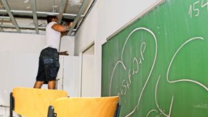 Ein Handwerker verschließt im Zuge der Elektrosanierung einen Wanddurchbruch an der Wolfbuschschule mit Steinwolle. Foto: Lichtgut - Oliver Willikonsky
