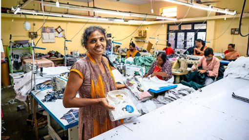 Manjula hat es durch einen Mikrokredit geschafft, als indische Frau unabhängiger zu werden. Hier steht die Geschäftsfrau stolz in ihrer eigenen Hemdenmanufaktur. Foto: Oikocredit/Ehrmann