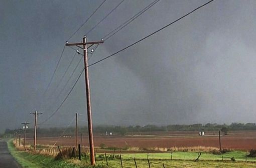 Auf diesem Video-Standbild bahnt sich die  riesige trichterförmige Gewitterwolke eines Tornados ihren Weg über eine Straße (Szene aus dem US-Bundesstaat Oklahoma vom 20. April 2023). Foto: Uncredited/KOCO-TV/AP/dpa
