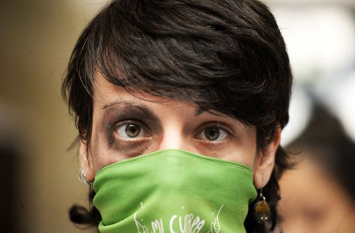 Eine Frau mit einem symbolisch geschminkten Auge und verbundenem Mund nimmt an einer Performance am internationalen Tag gegen Gewalt an Frauen  in Chile teil. Foto: dpa