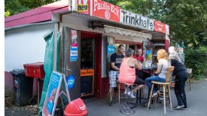 Kiosk-Besitzer Thomas Paul (links) sitzt mit Kunden vor seiner Trinkhalle „Paulis Eck“ in Essener Stadtteil, Altenessen. Foto: dpa