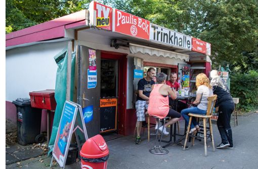 Kiosk-Besitzer Thomas Paul (links) sitzt mit Kunden vor seiner Trinkhalle „Paulis Eck“ in Essener Stadtteil, Altenessen. Foto: dpa