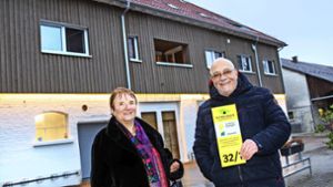 Dorothea und Wilfried Veeser mit dem Hausnummernschild, das ihren Neubau als vorbildhaftes „Klimahaus“ ausweist. Foto: Ines Rudel