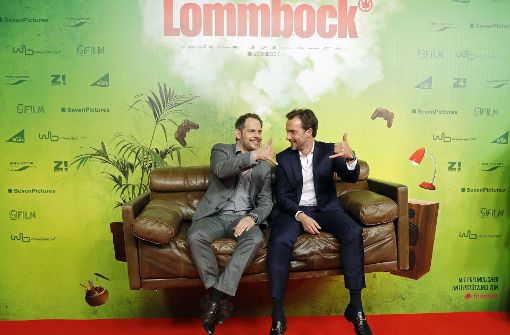 Moritz Bleibtreu (links) und Lucas Gregorowicz sitzen bei der Premiere ihres Films „Lommbock“ auf einem schwebenden Sofa. Foto: Getty Images