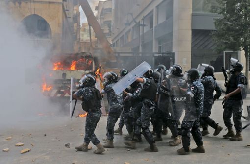 Die Polizei bahnt sich mit Schutzschildern ihren Weg. Foto: AFP/STR