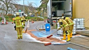 Die Feuerwehr streut die ausgelaufene Flüssigkeit mit Besen und einem Ölbindemittel ab. Foto: Andreas Rometsch/Feuerwehr Korntal-Münchingen