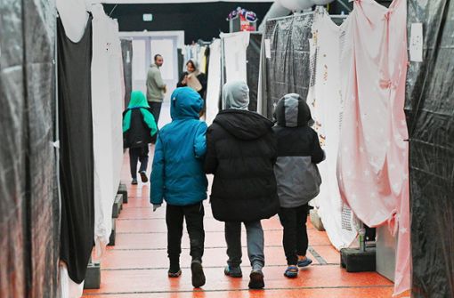 Flüchtlingskinder gehen durch ein Zelt einer deutschen Flüchtlingsunterkunft. (Archivbild) Foto: dpa/Arne Dedert