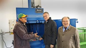 Ein Mitarbeiter des neuen Wertstoffhofs zeigt dem Landrat Roland Bernhard (Mitte) und dem Böblinger Abfallchef Wolfgang Bagin, wie die Kunststoffpresse funktioniert Foto: StZ