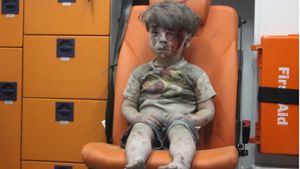 Dieses traurige Bild geht um die Welt: Der kleine Omran sitzt nach einen Luftangriff in Aleppo verstört in einem Rettungswagen. Foto: AFP