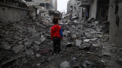 Ein Junge steht vor den Trümmern nach einem Luftangriff im Flüchtlingslager Maghazi im Zentrum des Gazastreifens. Schon sechs Monate lang tobt der Gaza-Krieg. Foto: Uncredited/XinHua/dpa