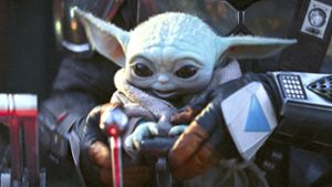 Der Mandalorian (Pedro Pascal) lässt Baby Yoda ans Steuer seines Raumschiffs. Foto: Lucasfilm