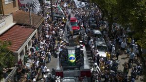 Der Trauerzug mit dem Sarg des brasilianischen Fußball-Idols Pelé führt auch am Haus seiner Mutter Celeste Arantes in seiner Heimatstadt Santos vorbei. Foto: dpa/Matias Delacroix