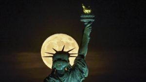 Der Supermond  geht hinter der Freiheitsstatue in New York auf. Weitere Impressionen des Vollmondes finden Sie in unserer Galerie. Foto: dpa/J. David Ake
