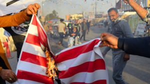Menschen im Irak verbrennen die US-amerikanische Flagge. Foto: AFP/HAIDAR HAMDANI