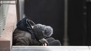 Ein Obdachloser schläft auf einer Treppe des Hauptbahnhofs in Frankfurt. Foto: dpa/Boris Roessler