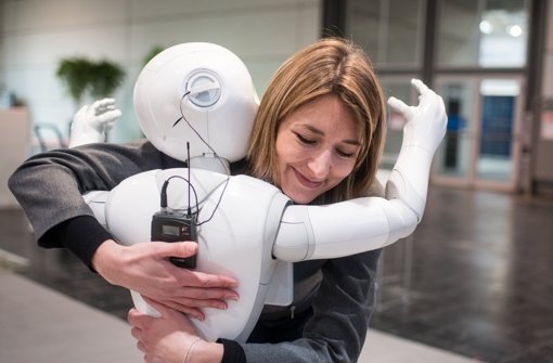 Die Kommunikationsmanagerin von Aldebaran, Aurora Chiquot, umarmt  auf dem Messegelände der CeBIT den humanoiden Roboter „Pepper“. Foto: dpa
