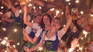 Ein Bild aus vergangenen Zeiten: Bedienungen stehen im Hofbräu-Zelt beim traditionellen Kehraus auf den Tischen, halten dabei Wunderkerzen in den Händen und feiern. Foto: dpa/Felix Hörhager