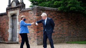 Merkel und Johnson begrüßen sich coronagerecht. Foto: AFP/David Rose
