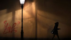 Eine Frau läuft nachts durch eine spärlich beleuchtete Straße. Eine Situation, in der die Angst vor dem Unbekannten durchaus berechtigt ist. Foto: dpa