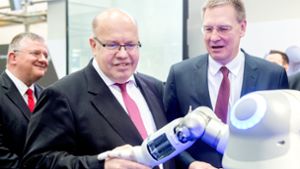 Festo-Chef  Oliver Jung (rechts) mit Wirtschaftsminister Peter Altmaier. Die    Roboterhand  von Festo ist ein  Publikumsmagnet  auf der Messe in Hannover. Foto: dpa