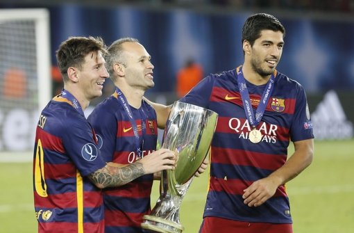 Lionel Messi, Andres Iniesta und Luis Suarez (von links) von Barcelona mit dem Supercup-Pokal. Foto: dpa