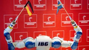 Deutsch-schwedische Partnerschaft  auf der Hannover-Messe: Ein Roboter des deutschen Herstellers IBG schwenkt die beiden Nationalflaggen. Foto: dpa