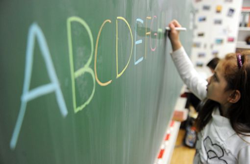 Eine Schülerin einer zweiten Klasse schreibt in einer Schule das ABC an die Tafel. Foto: dpa/Daniel Reinhardt