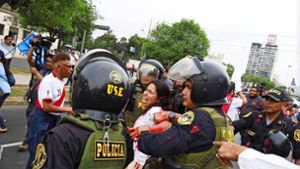 Unruhen in Lima, Peru, am 3. Januar: Eine Frau wird verhaftet, nachdem sie rote Farbe auf Polizisten geworfen hat. Foto: imago/Carlos Garcia Granthon