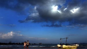 Touristen gehen am Strand von Mirissa in Sri Lanka entlang Foto: dpa