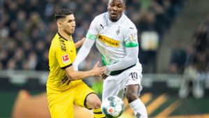 Dortmunds Achraf Hakimi (l.) und Gladbachs Marcus Thuram kämpfen um den Ball. Foto: dpa/Marcel Kusch