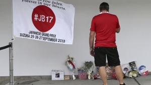 An der Rückseite der Manor-Marussia-Box wurde in Suzuka eine Fahne platziert, Fans legen Erinnerungsstücke an Jules Bianchi ab. Foto: AP