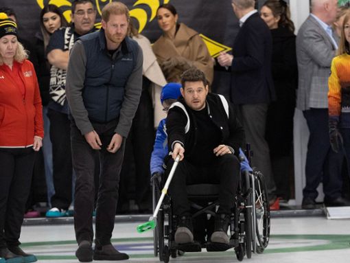 Voller Einsatz: Michael Bublé probierte neben Prinz Harry Rollstuhl-Curling aus. Im Hintergrund schaute Meghan zu. Foto: IMAGO/i Images