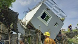 Rettungskräfte stehen vor einem eingestürzten Wohngebäude in Ilocos Sur. Foto: dpa/Uncredited