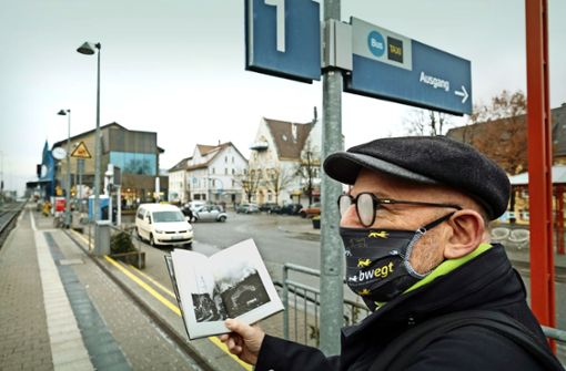 Vorher und nachher: Verkehrsminister Winfried Hermann zeigt anhand seines Buches, wie der Bahnhof seiner Heimatstadt Rottenburg einst ausgesehen hat. Foto: Lichtgut/Leif Piechowski