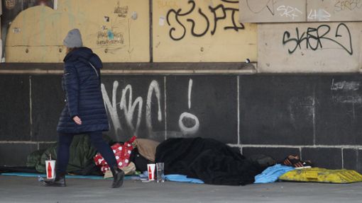 Frau geht an Obdachlosen vorüber. In Baden-Württemberg gibt es mehr als 1,5 Millionen Menschen in Armut. (Symbolbild) Foto: IMAGO/Hanno Bode/IMAGO/Hanno Bode